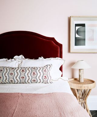 Pink bedroom with pale pink wall and red velvet headboard