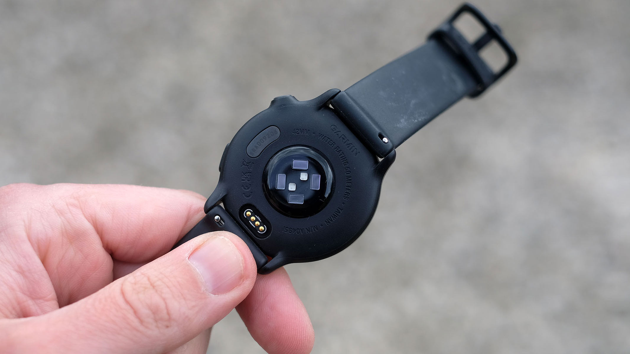 Garmin Vivoactive 6, o imagine de aproape a senzorului de frecvență cardiacă și a unui port de încărcare
