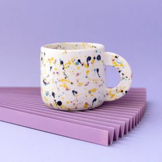 Modern splatter mug on lilac background