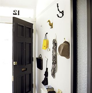 room with black door and hanging bags and umbrella