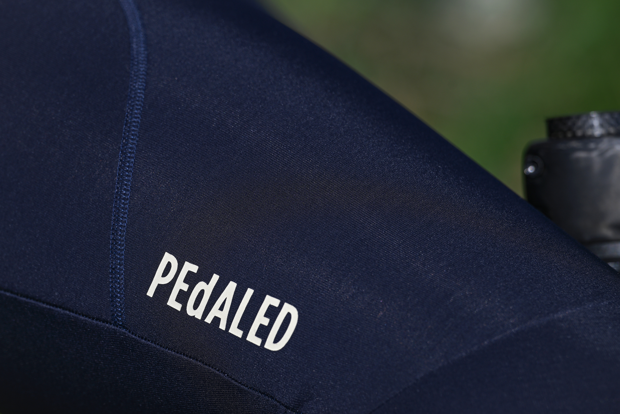close up of the PEdALED logo on the thigh of some dark blue tights