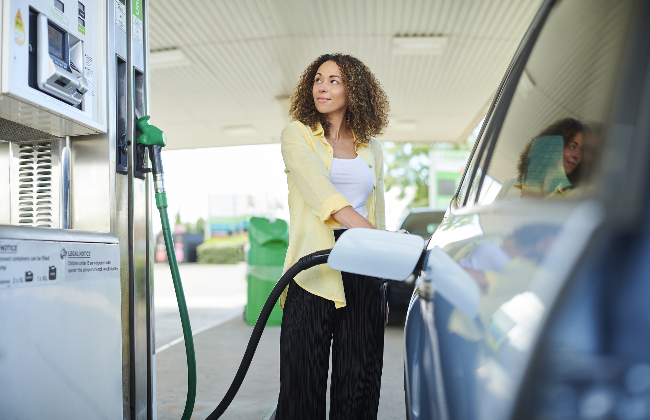 Woman fills up car at petrol pump
