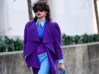 a person wears a purple jacket and blue pants