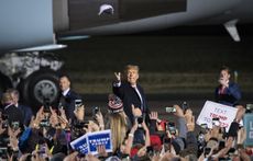 U.S. President Donald Trump tosses a cap at attendees as he arrives at a rally in Duluth, Minnesota, on Wednesday, Sept. 30, 2020.