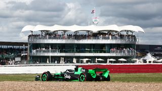 Valtteri Bottas in his green Kick Sauber F1 car in front of the grandstand at Silverstone at the British Grand Prix.
