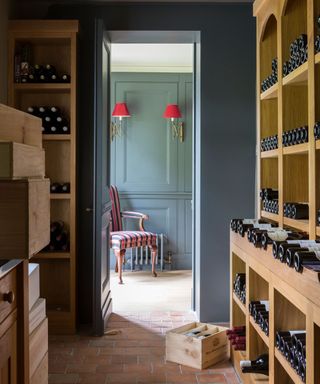 wine cellar with blue walls, teracotta tiled flooring and crates