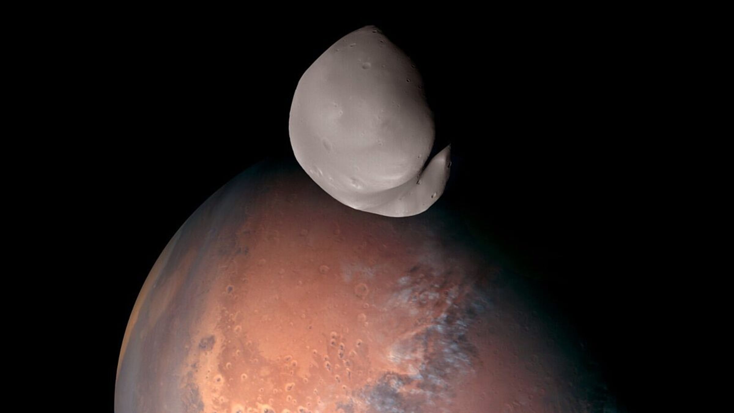 A close-up photo of Deimos in front of Mars