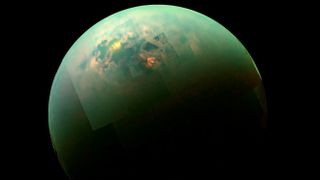 A near-infrared, color view of Titan shows sun glistening off the moon's north polar seas