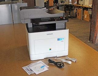 The Samsung ProXpress C3060W includes a quick start guide, user manual, software drivers on CD, and cables for power USB and fax.