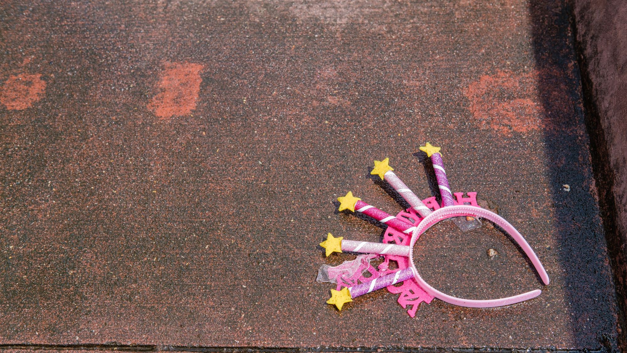 Discarded Upside Down Happy Birthday Tiara on the Ground