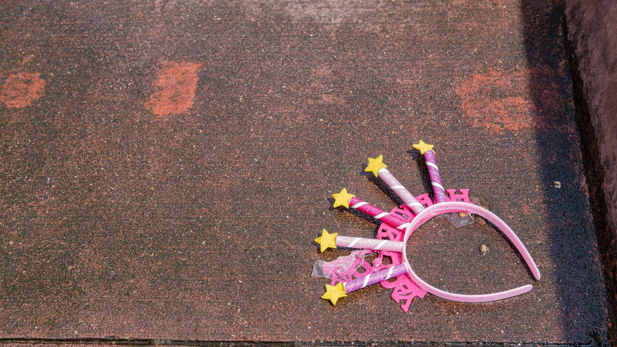 Discarded Upside Down Happy Birthday Tiara on the Ground