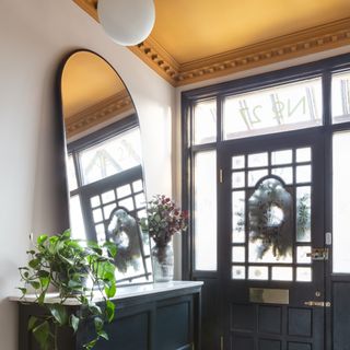 A hallway with a contrasting yellow ceiling with moulding