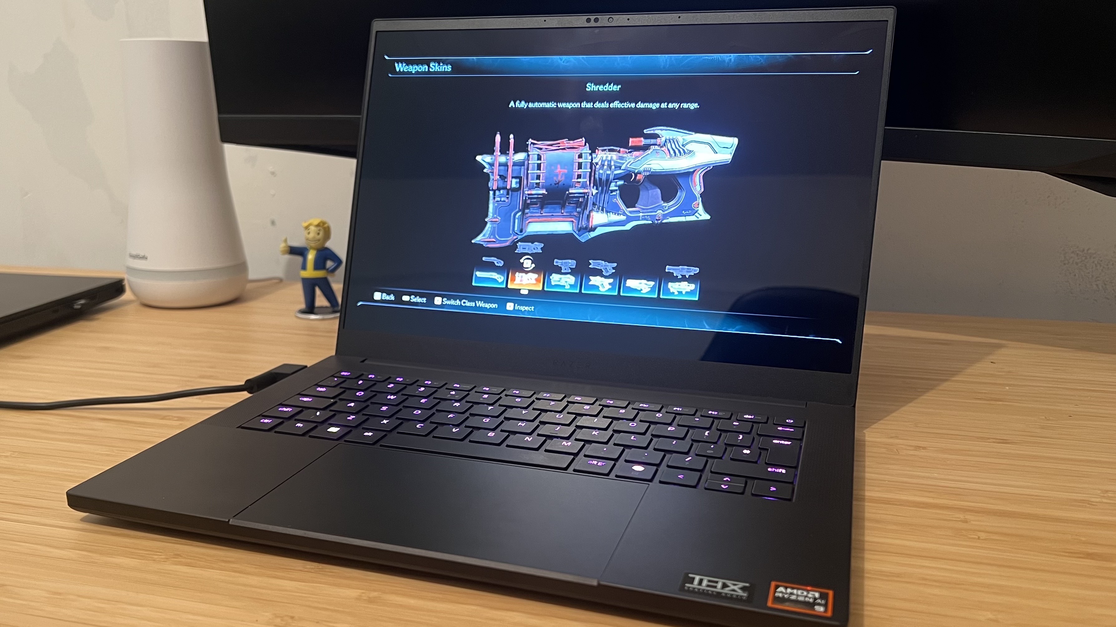 Razer Blade 14 running Doom: The Dark Ages on a wooden desk