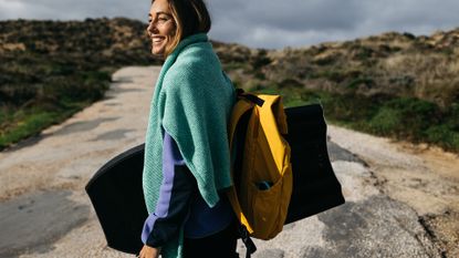 best fleece jacket: surfer spending time outdoors wearing Finisterre clothes and wetsuits