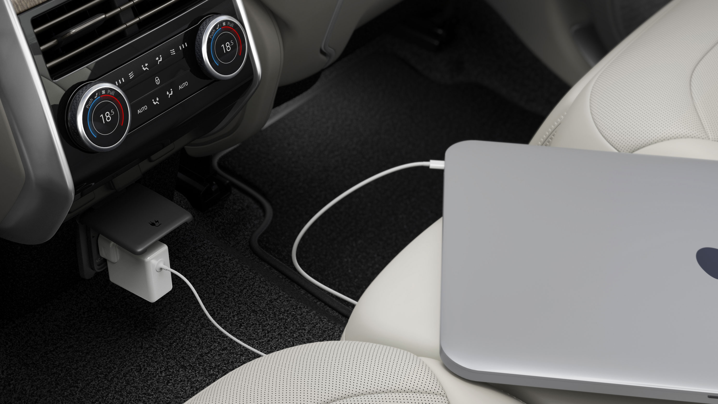 Laptop plugged into a full-size power outlet in a car