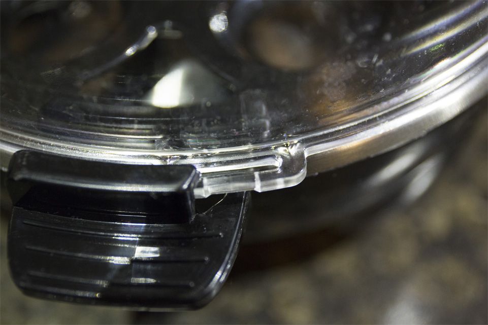You slide the lid into a secure holding position so a small handle on each side fits into two holding devices located on the base.
