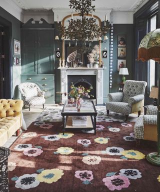 grand living room with floral rug and fireplace and chandelier