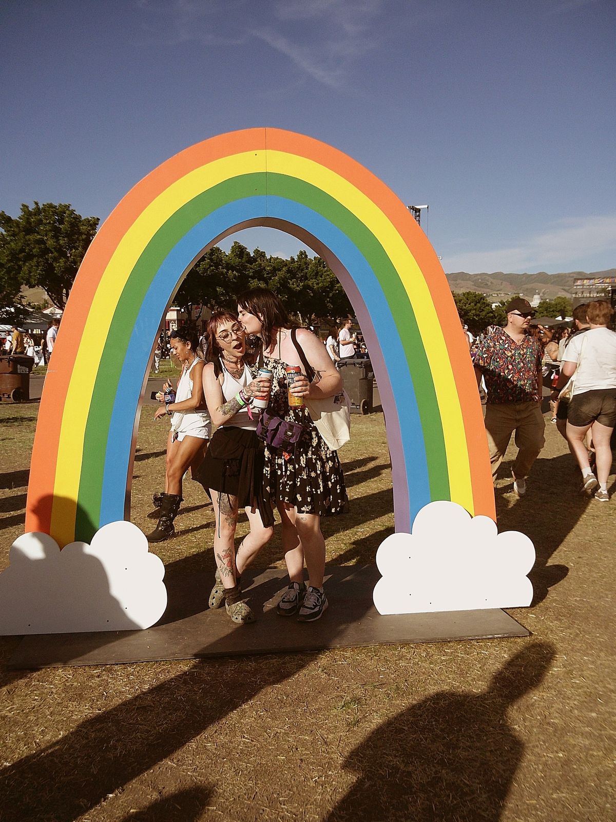 Sample image taken with Camp Snap 2 digital camera, showing young women posing at a festival under a rainbow decal