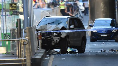 A white SUV sits next to police working at the scene of a Melbourne attack.