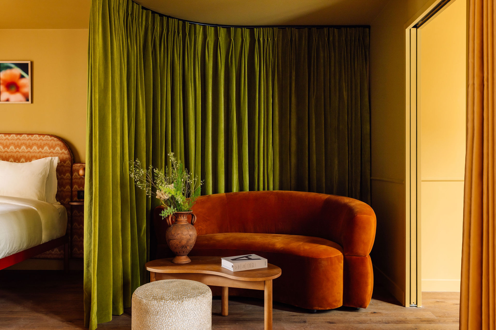 A brightly decorated, patterns and plush textiles-filled hotel's rooms and common spaces feature an earthy palette ranging from ochre and green to terracotta, orange, and brown.