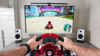 Playing Mario Kart World with the Hori Pro Deluxe racing wheel in TV mode on a desk