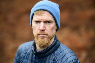 Viltrox AF 85mm F1.4 Pro lens sample gallery: man in a blue beanie, with blurry bronze-colored ferns in the background