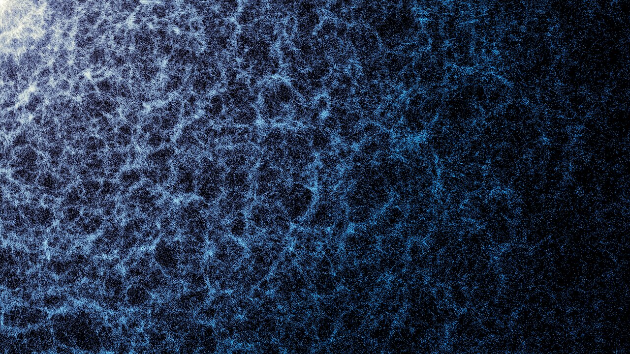 A blue and white map against a dark background. The denser areas indicate regions where galaxies and galaxy clusters have clumped together to form the strands of the cosmic web. 