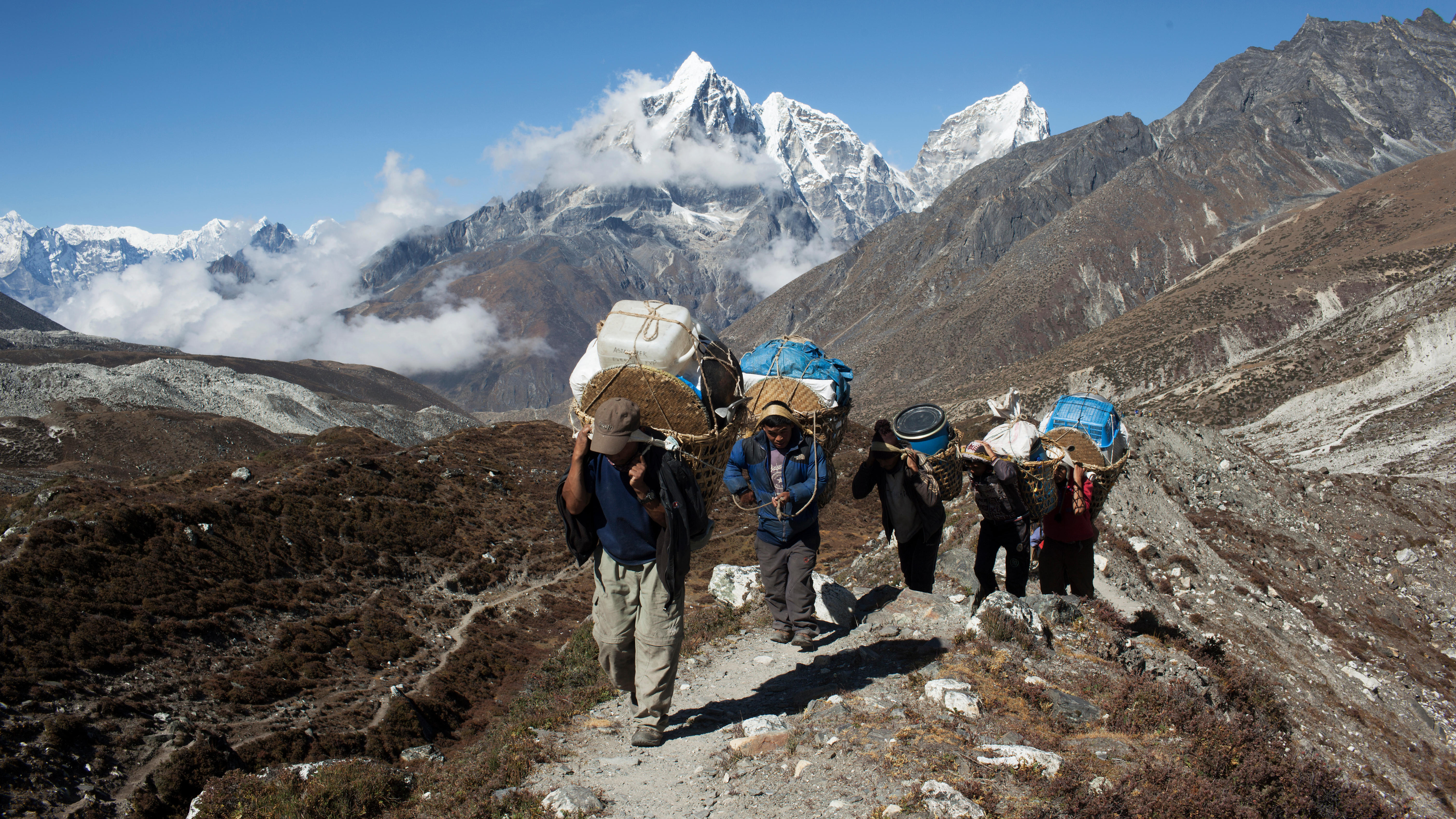 A group of Sherpa walk up a mountain in the Everest region