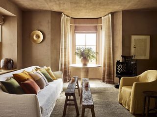 Warm, earthy living room with a mixture of golds and browns in the curtains, furniture and wall colors