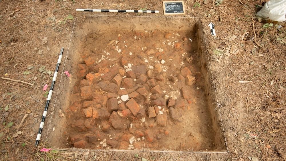 An aerial view of a dirt archaeological excavation site. 