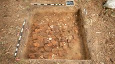 An aerial view of a dirt archaeological excavation site. 