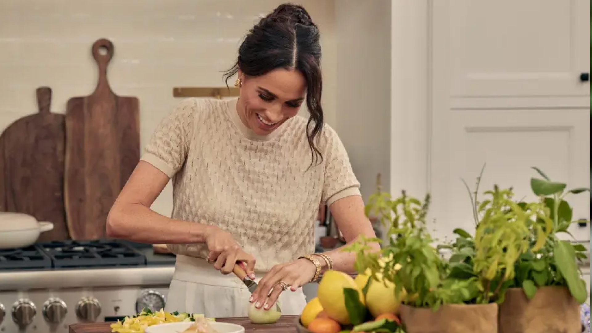 Meghan Markle cutting fruit on a kitchen table in her show With Love, Meghan