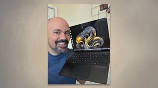 Rhener Furtado proudly holds a 50th Anniversary Surface Laptop featuring an elegant gold design, showcasing its stylish appearance.