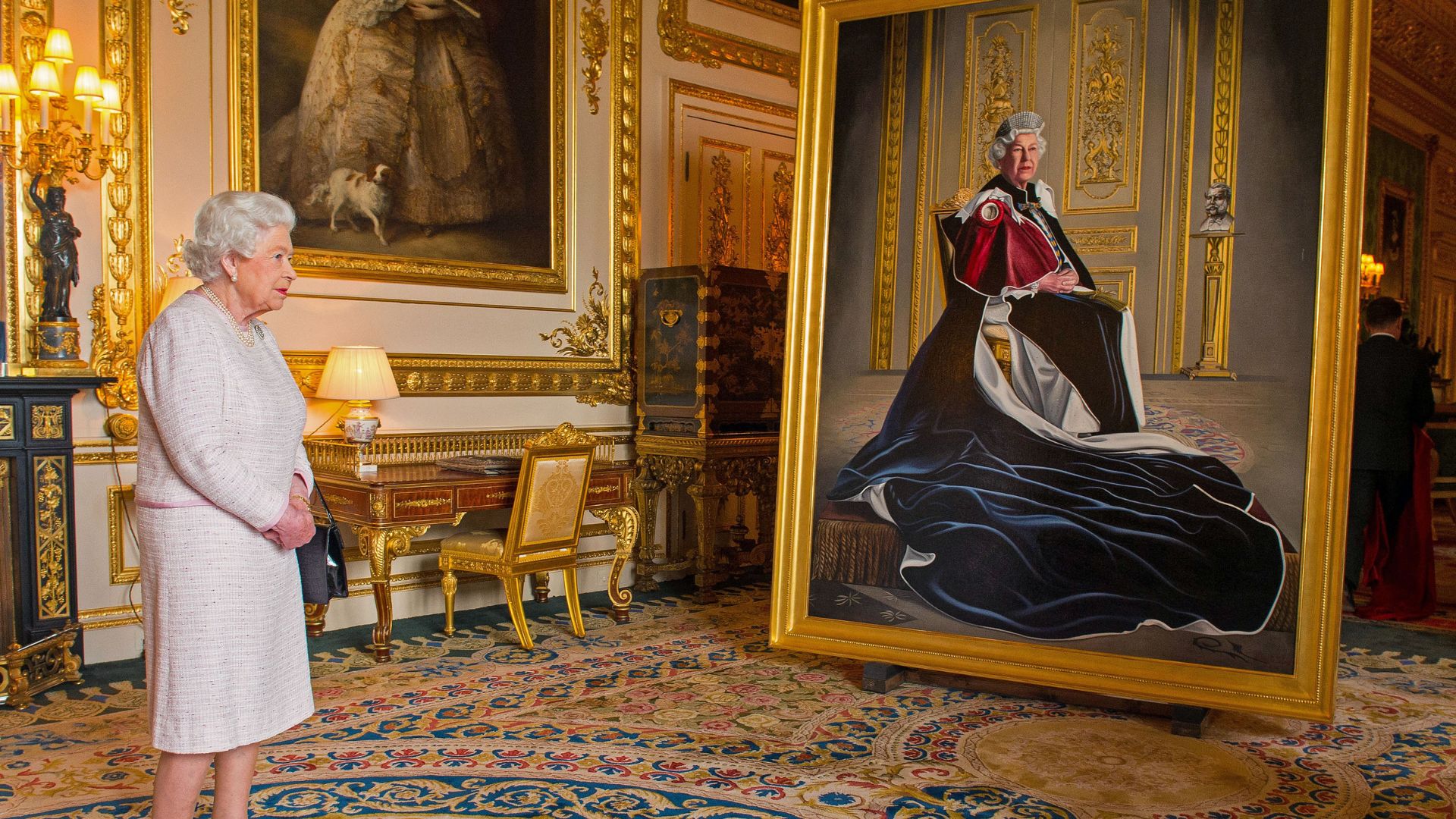 Queen Elizabeth looks at a portrait of herself