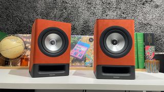 Technics SC-CX700 music system on white shelf with busy shelf behind