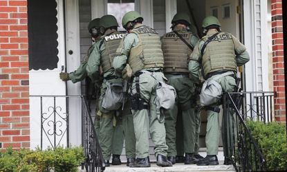 SWAT team members go door to door in search of the Boston bombing suspects in Watertown, April 19.