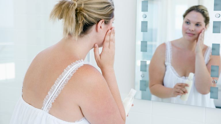 How to lose weight from your face? Woman staring at her face in the mirror