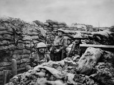 Black and white photo of three soldiers standing in a trench