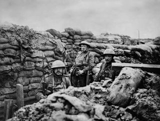 Black and white photo of three soldiers standing in a trench