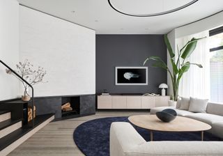 White and grey living room with beige sofas and blue circle rug