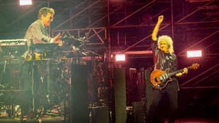 Jean-Michel Jarre on the left, and Brian May with his signature red guitar on the right, performing on stage