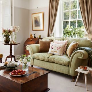 living room with green sofa and antique furniture pieces