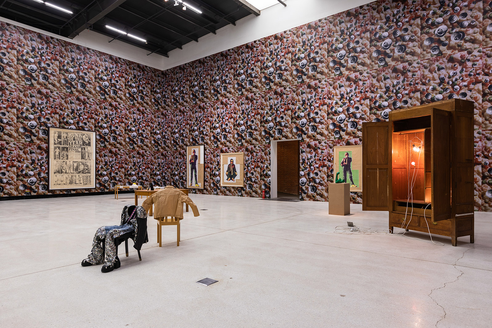 Clothes hanging on wooden chairs and framed pictures of decorated wallpaper