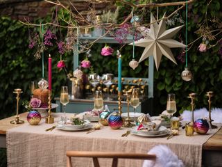 Christmas table scene outside, baubles, gold candle holders gold star, linen tablecloth