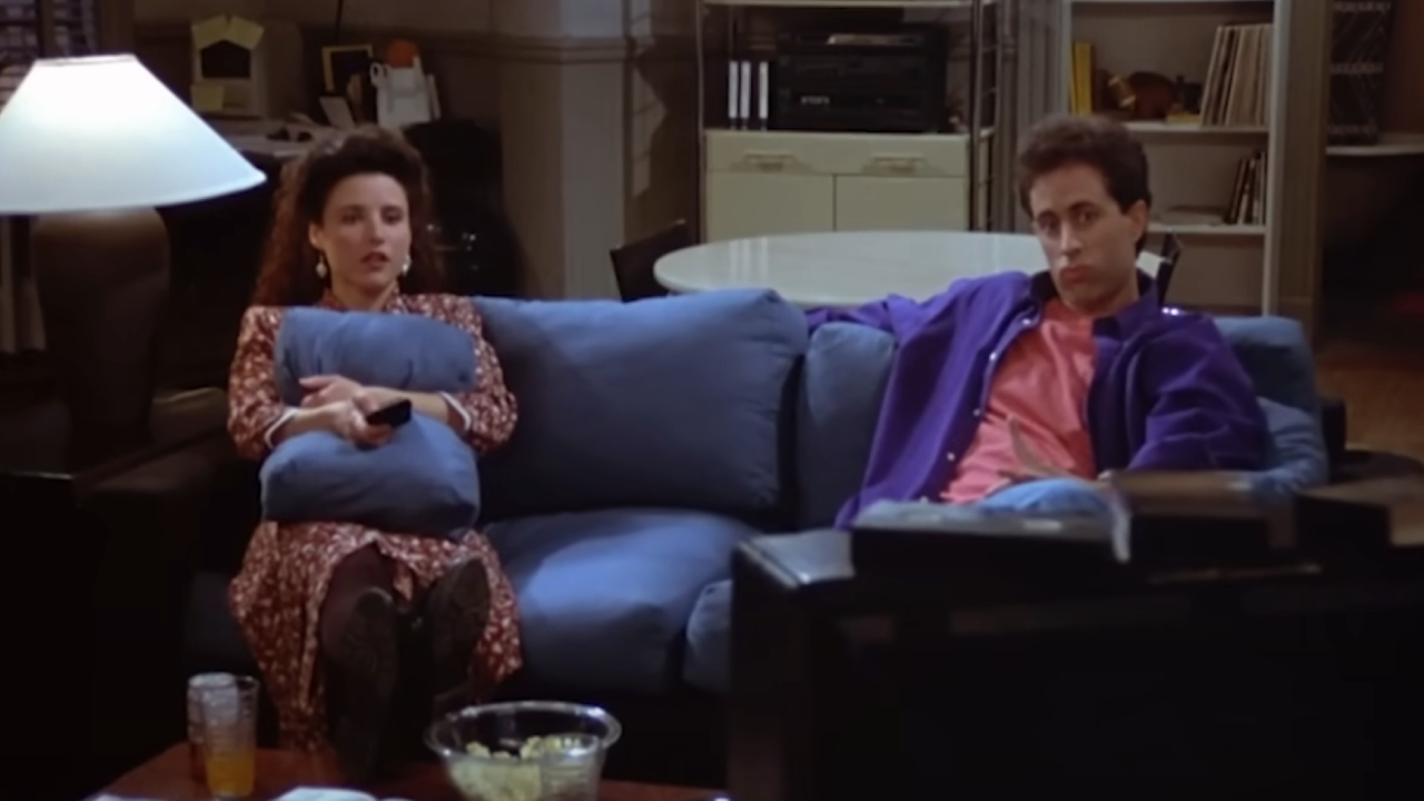 Julia Louis-Dreyfus and Jerry Seinfeld sitting on a couch on Seinfeld