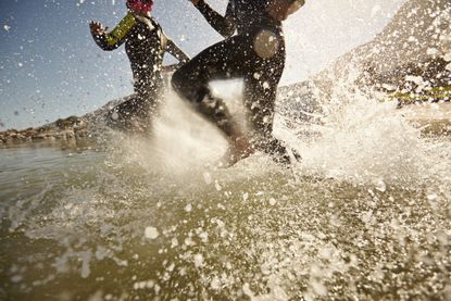 Two people running into the water.