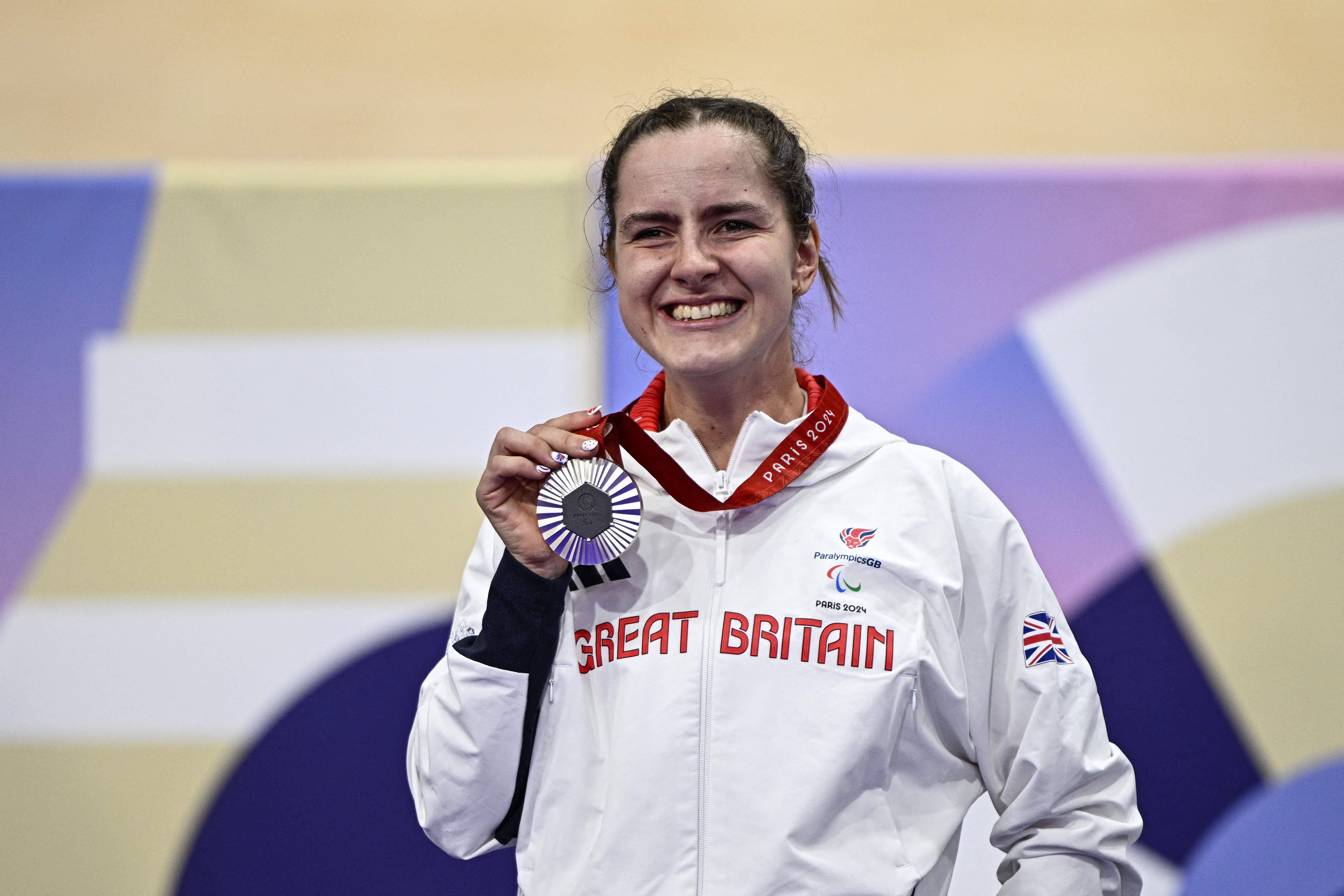 Daphne Schrager celebrates on the podium of the women's C1-3 3000m cycling individual pursuit track event during the Paris 2024 Paralympic Games