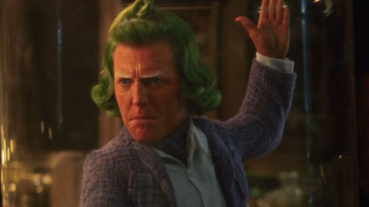 Oompa Loompa Hugh Grant strike an angry dancing pose in Wonka.