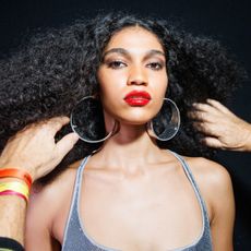 a model wearing smokey eyeshadow and red lipstick backstage at the DSquared2 fall 2025 show