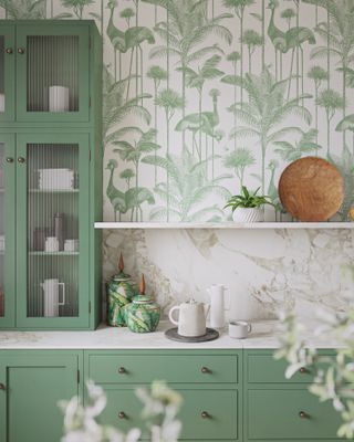 green kitchen with green crane wallpaper, green countertop cabinet with fluted glass, shelf, marble backsplash and countertop